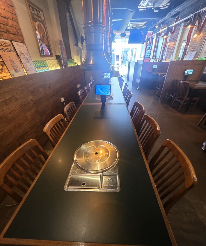 Long Korean barbecue table arranged for a group at Hongdae